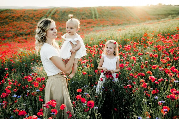 Uma mulher olha para o bebê e a filha mais velha olha para eles