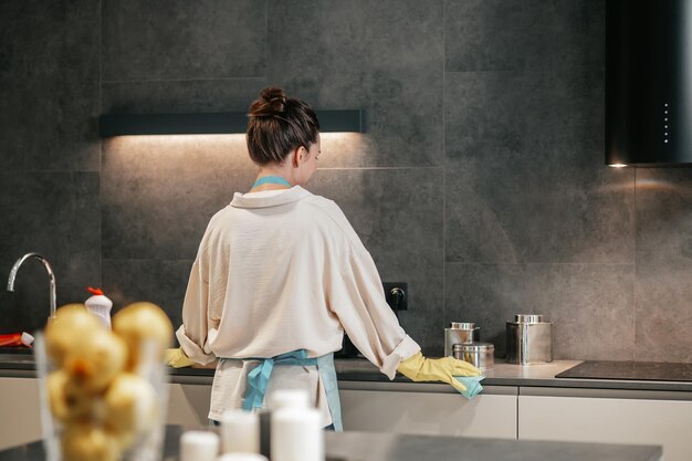 Uma mulher parecendo ocupada enquanto limpa a cozinha