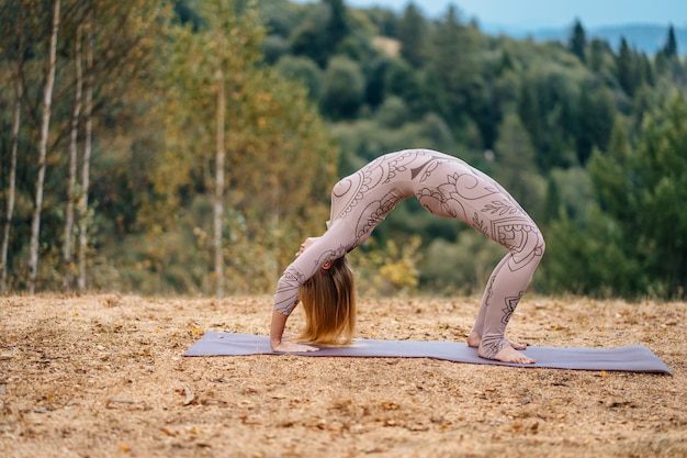 Uma mulher pratica ioga de manhã em um parque ao ar livre.