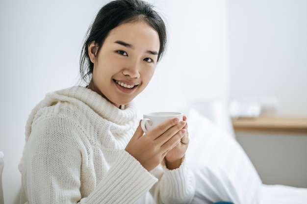 Uma mulher segura uma xícara de café.