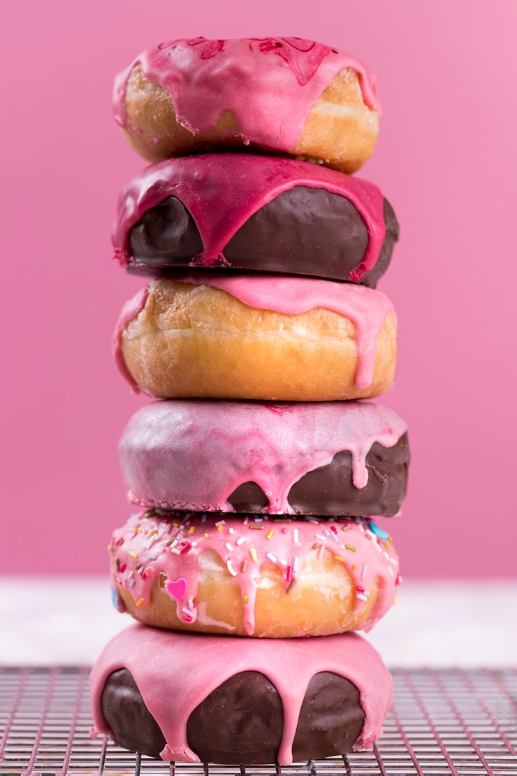 Foto grátis uma pilha de donuts saborosos, vista de frente.