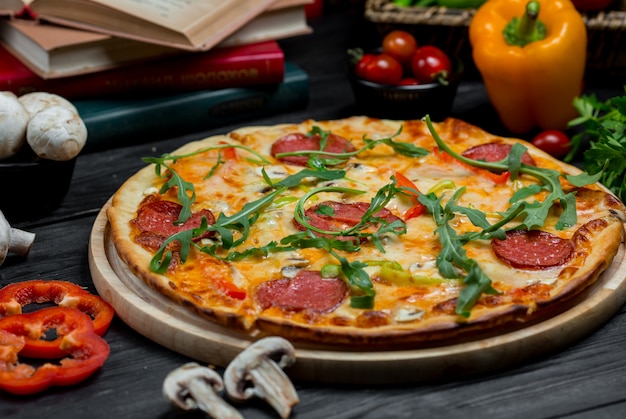 Uma pizza de pepperoni clássica com queijo derretido e verdura no topo