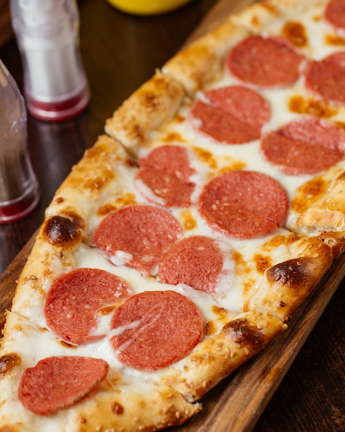 Foto grátis uma pizza de salsicha vista de cima em uma mesa de madeira marrom comida fast-food italiana