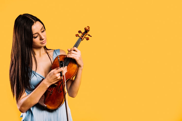 Foto grátis uma rapariga a tocar violino.