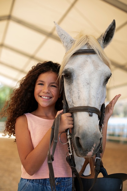 Uma rapariga de tiro médio com um cavalo lindo.