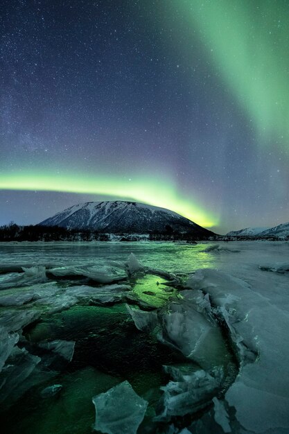 Uma sequência vertical de montanhas nevadas sob uma luz polar