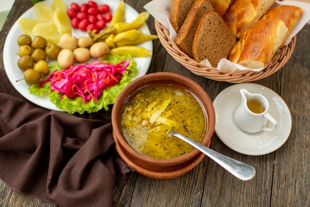 Uma sopa quente de vista frontal, juntamente com legumes frescos e fatias de pão