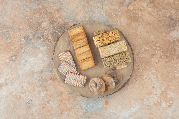 Uma tábua de madeira cheia de biscoitos doces e pedaços de amendoim