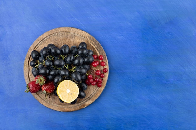 Uma tábua de madeira cheia de frutas e limão fatiado