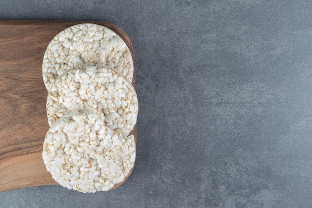 Uma tábua de madeira com pão de arroz tufado.