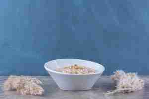 Foto grátis uma tigela branca com saboroso mingau de aveia saudável no café da manhã.