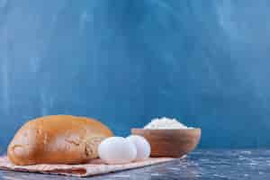 Foto grátis uma tigela de farinha, lavash e pão fatiado em um pano de prato, na mesa azul.