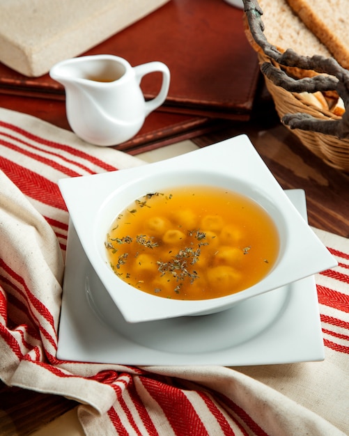 Uma tigela de sopa de bolinho de massa dushbara servido com vinagre