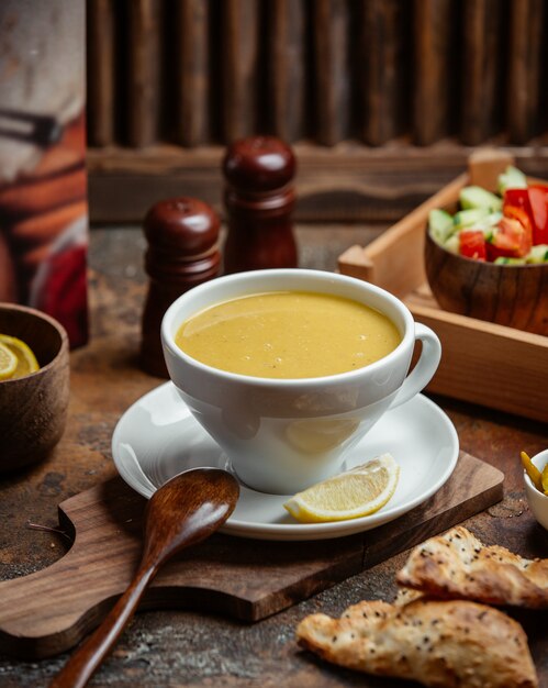 uma tigela de sopa de lentilha servida com limão