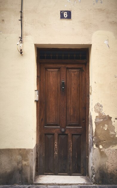 Uma tomada vertical de uma porta de madeira com o número 6 acima dela