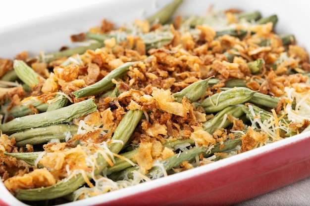 Uma tradicional caçarola de feijão verde coberta com cebola frita francesa e creme de cogumelo em mármore branco