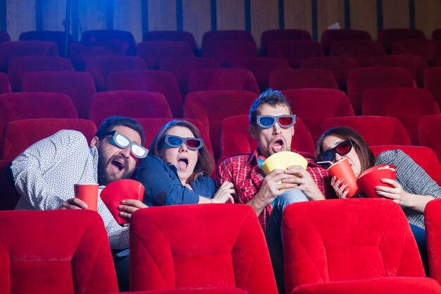 Uma variedade de emoções humanas de amigos segurando uma cola e pipoca no cinema.