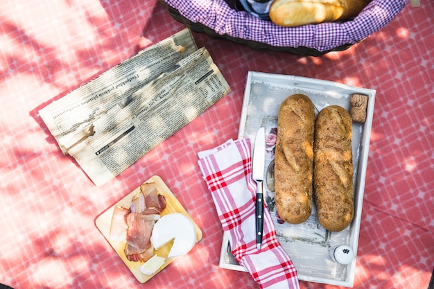 Foto grátis uma visão aérea da bandeja com pão; bacon; queijo no pano vermelho