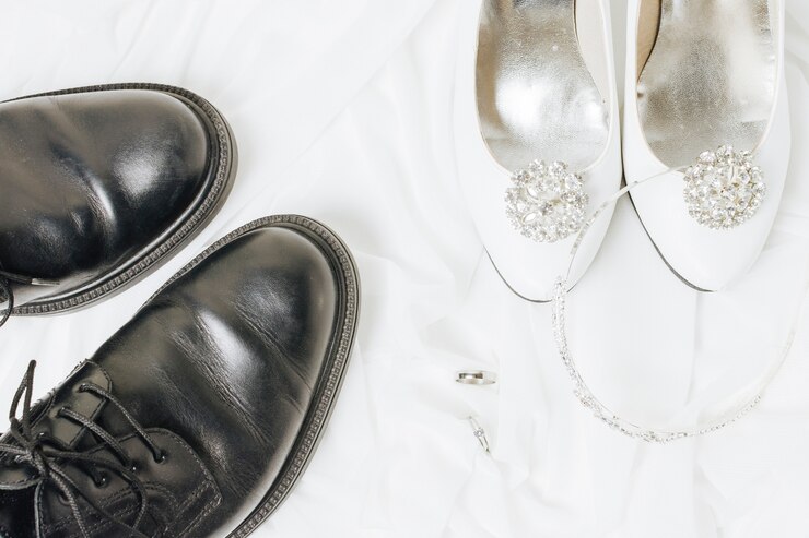 Foto grátis uma visão aérea de alianças de casamento; coroa e sapatos no pano branco