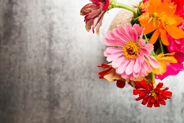 Foto grátis uma visão aérea de flores coloridas no vaso no pano de fundo texturizado