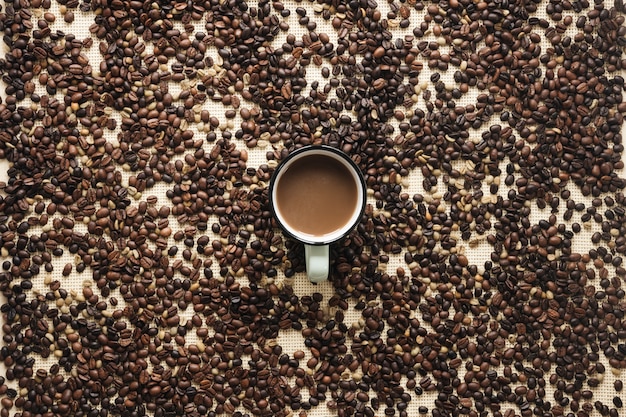 Uma visão aérea de grãos de café torrados e xícara de café