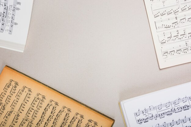 Uma visão aérea de livros de nota musical sobre fundo branco, com espaço para texto