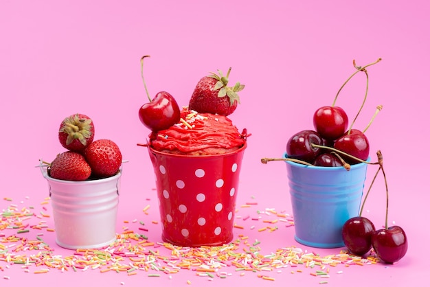 Uma visão frontal de frutas vermelhas frescas dentro de pequenos baldes na cor rosa, frutas vermelhas