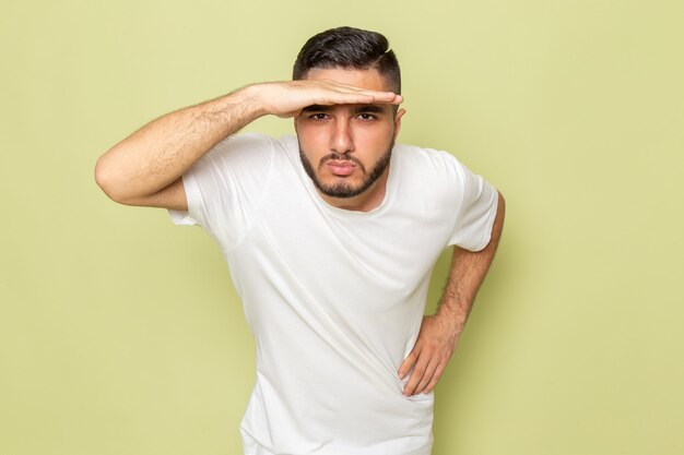 Uma visão frontal de um jovem do sexo masculino em uma camiseta branca olhando para longe