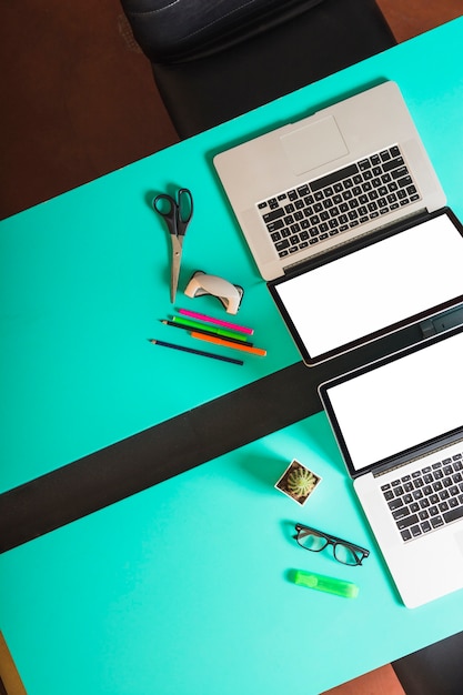 Foto grátis uma visão geral do espaço de trabalho separado com dois laptops e papelarias