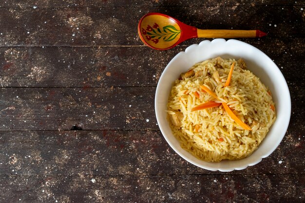Uma vista de cima arroz cozido salgado e apimentado saboroso dentro de prato redondo em marrom rústico