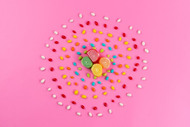 Uma vista de cima, marmelada e doces coloridos formando um círculo na cor rosa e doce