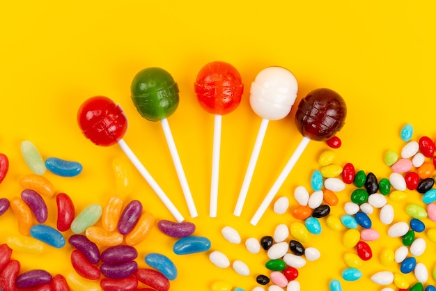 Foto grátis uma vista de cima pirulitos e balas doces coloridos isolados em confeitaria doce com açúcar