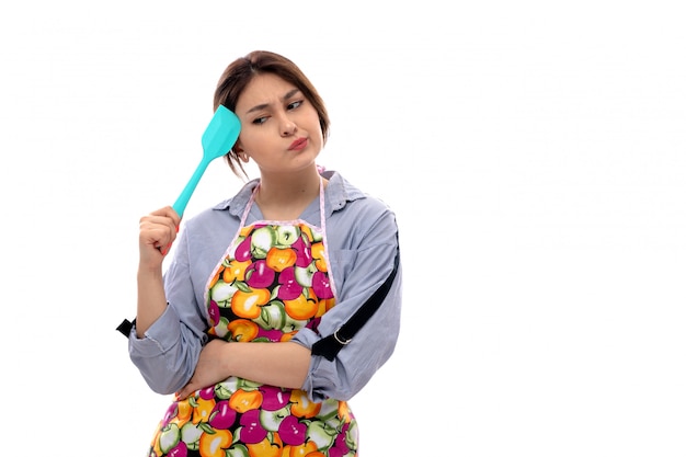 Foto grátis uma vista frontal bela moça de camisa azul clara e capa colorida pensando segurando o aparelho de cozinha azul