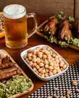Foto grátis uma vista frontal de carne frita com cerveja e nozes na mesa de madeira marrom refeição com nozes