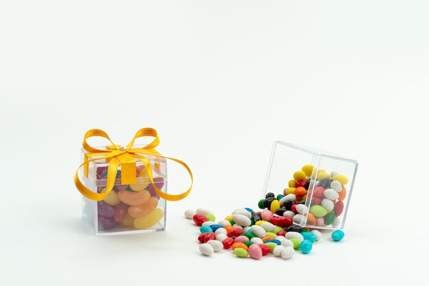Uma vista frontal de doces coloridos com geleias em branco, cor açúcar doce