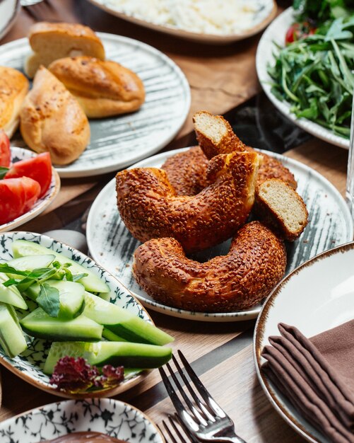 Uma vista frontal do café da manhã com pão de pepino e tomate na mesa