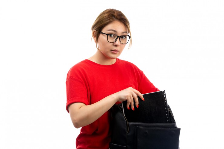 Foto grátis uma vista frontal jovem aluna em jeans t-shirt preto preto segurando o caderno em branco
