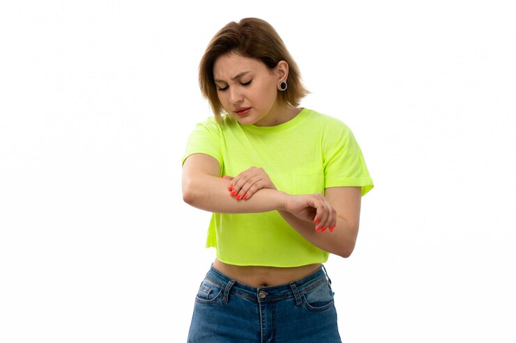Foto grátis uma vista frontal jovem atraente de camisa verde e calça jeans azul, sofrendo de dor de mão no branco