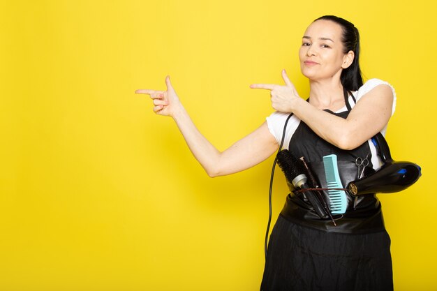 Uma vista frontal jovem cabeleireiro feminino na capa branca de camiseta preta sorrindo posando de boas-vindas