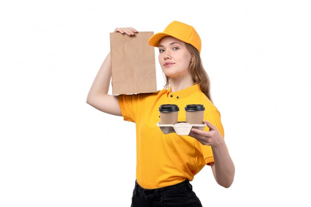 Uma vista frontal, jovem, correio feminino, trabalhador feminino, de, serviço entrega entrega, sorrindo, segurando, pacote alimento, e, café, copos