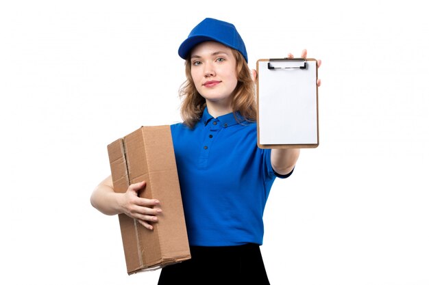 Uma vista frontal jovem correio feminino trabalhadora do serviço de entrega de comida segurando o pacote de alimentos e o bloco de notas em branco