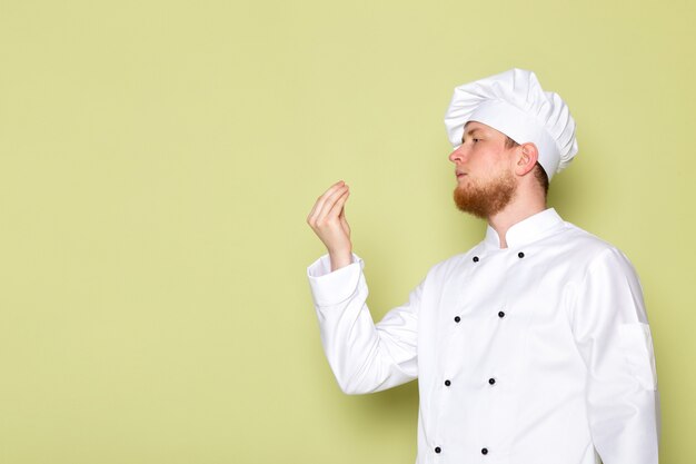 Uma vista frontal jovem cozinheiro masculino em branco cozinheiro terno branco cabeça