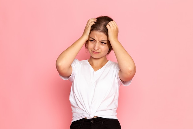 Uma vista frontal jovem fêmea bonita na camisa branca posando com expressão triste