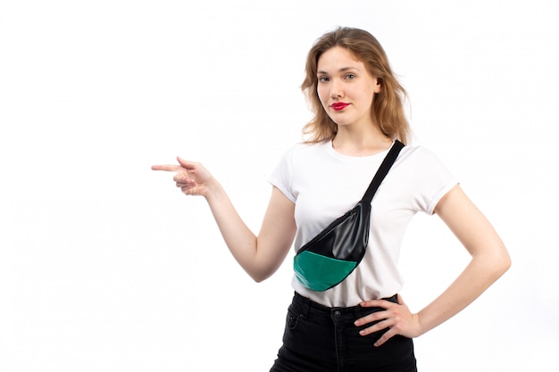 Uma vista frontal jovem fêmea em t-shirt branca e calça jeans preta, vestindo saquinho no branco