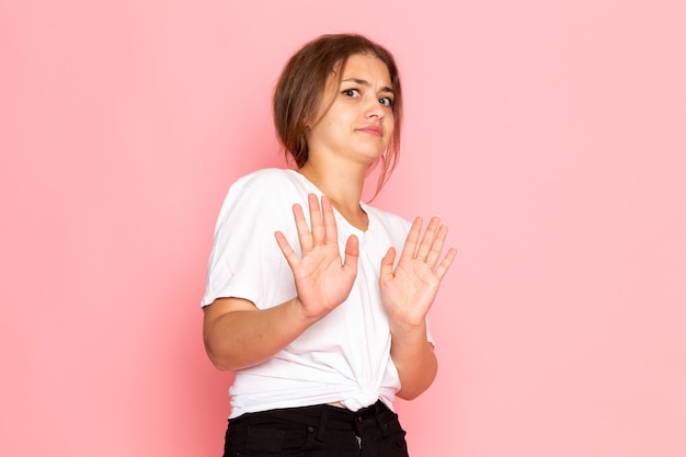 Uma vista frontal jovem mulher bonita na camisa branca com posando com expressão hesitante