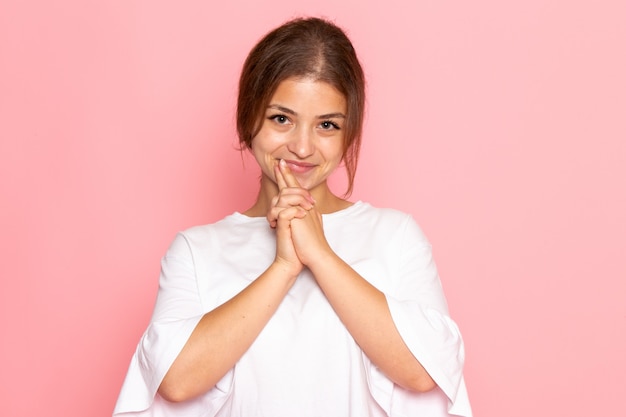 Uma vista frontal jovem mulher bonita na camisa branca posando com expressão encantada