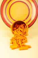 Foto grátis uma vista frontal macarrão dentro do cesto formado laranja cru dentro do cesto amarelo no fundo creme refeição alimentos massas