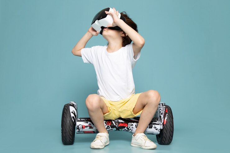 Foto grátis uma vista frontal menino sorridente jogando vr em segway no chão azul