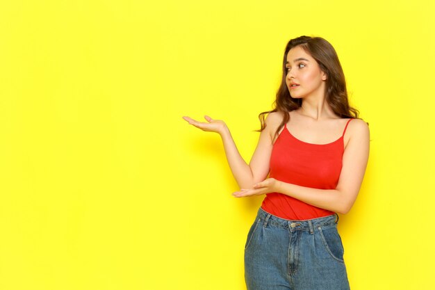 Uma vista frontal moça bonita camisa vermelha e azul jeans posando