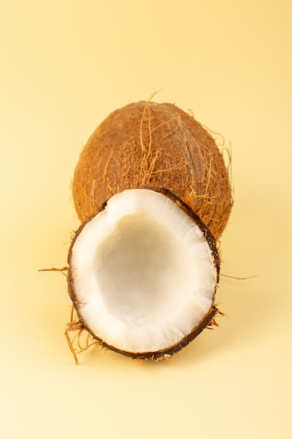 Uma vista superior coco coco fatiado leitoso fresco maduro isolado no creme colorido